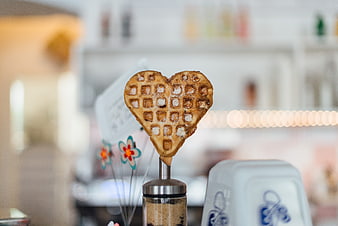 Heart-shaped waffle on a stick with sugar dusting