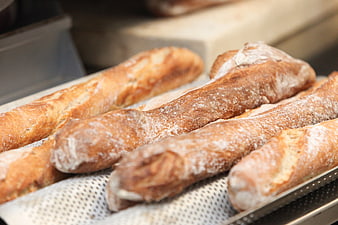 Freshly Baked French Baguettes On A Perforated Metal Tray