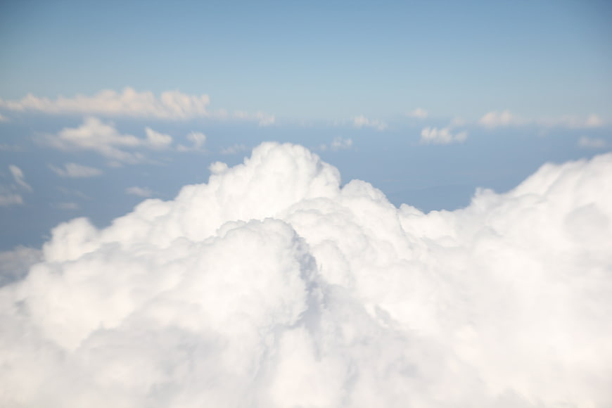 Aerial View Of Fluffy White Cumulus Clouds In Blue Sky