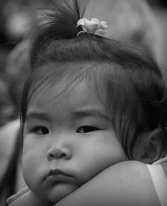 Black and white portrait of a cute baby girl with a flower hair clip