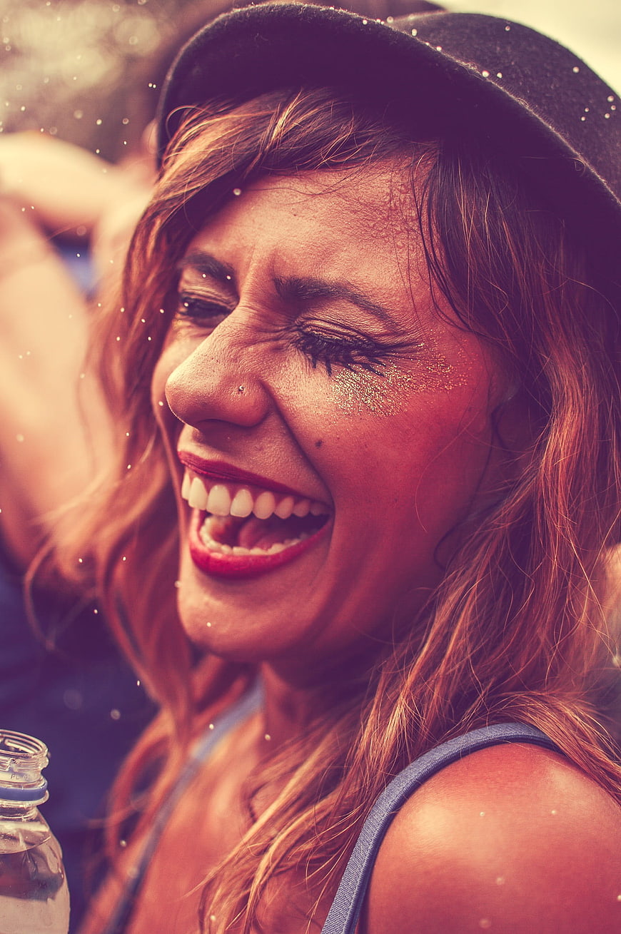Joyful Woman Laughing At Music Festival With Glitter Makeup