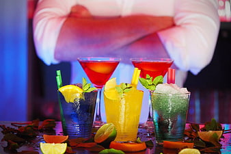 Colorful cocktails on bar counter with bartender background