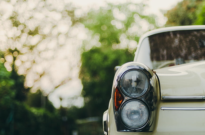 Close-up of vintage car headlight with bokeh background