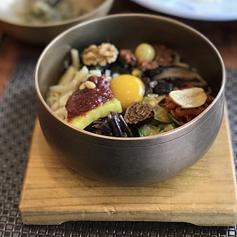 Korean Bibimbap Bowl with Raw Egg Yolk and Vegetables