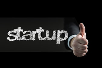 Businessman giving thumbs up next to startup text