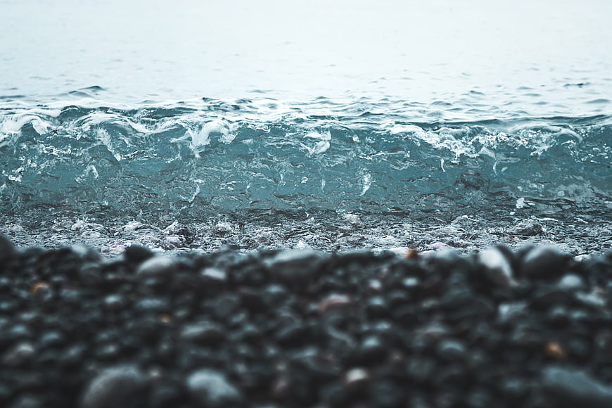Close-up of ocean waves crashing on a pebble beach