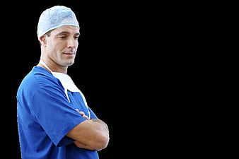 Male Dentist In Blue Scrubs And Surgical Cap Isolated On Black Background