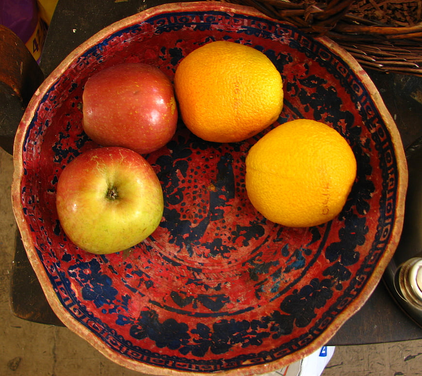 Top view of apples and oranges in a patterned bowl