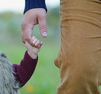 Father and daughter holding hands in a park