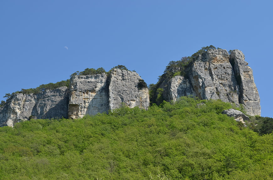 Limestone cliffs with green forest and blue sky