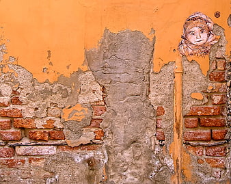 Street art mural of a child on weathered orange brick wall