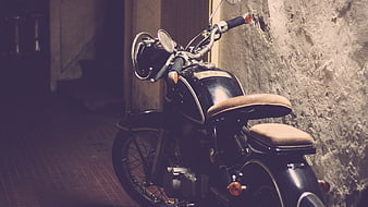 Vintage Black Motorcycle Parked Against Textured Wall