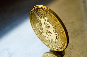 Gold Bitcoin Coin Standing On Textured Surface