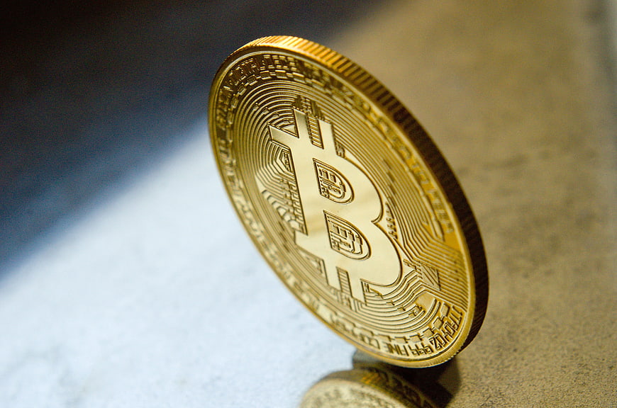 Gold Bitcoin Coin Standing On Textured Surface