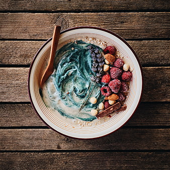 Top view of blue spirulina smoothie bowl with raspberries and nuts