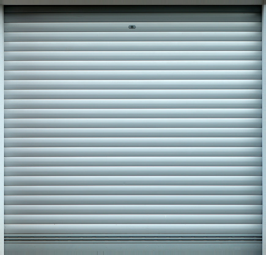 Closed gray metal rolling shutter gate with horizontal slats