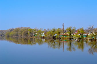 Serene River Landscape with Reflections and Spring Trees
