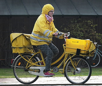 Deutsche Post Courier Riding Yellow Bicycle in Rain Gear