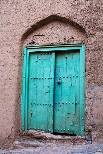 Weathered Teal Wooden Door Set In Ancient Earthen Wall