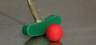Green Mini Golf Putter And Red Ball On Gray Surface
