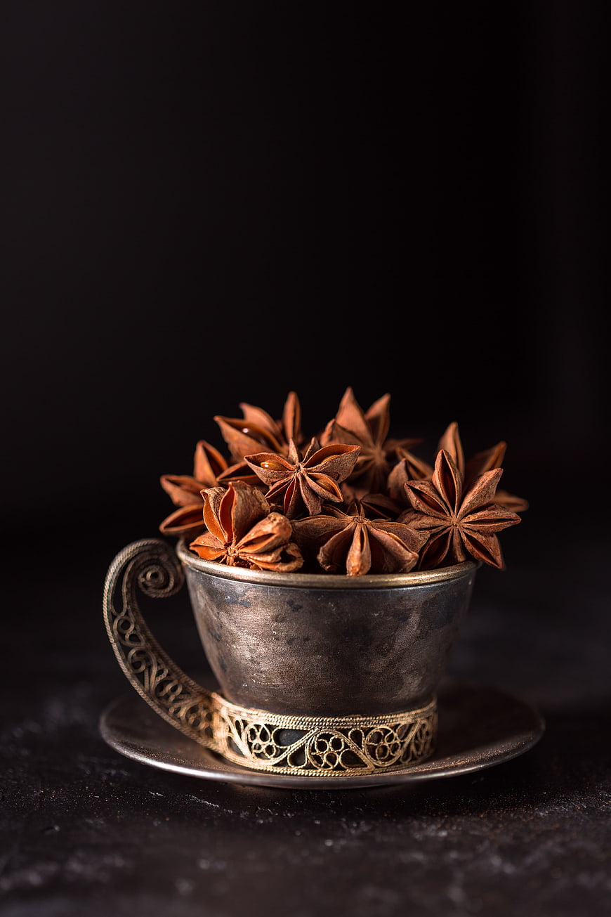 Star Anise Spices in Vintage Silver Cup on Dark Background