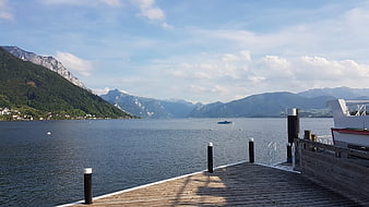 Wooden pier on Traunsee lake with mountains in Austria