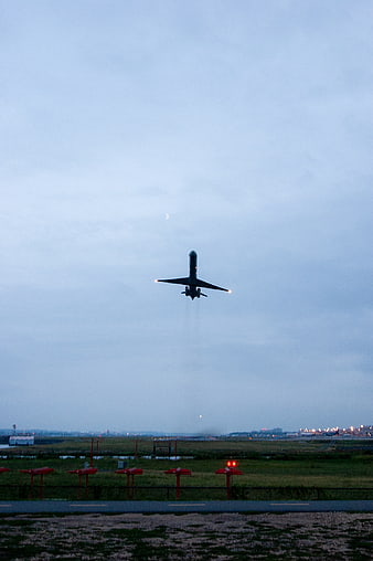 Airplane Taking Off at Dusk Over Airport Runway