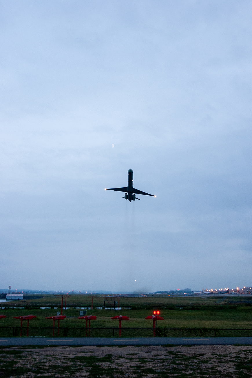Airplane Taking Off at Dusk Over Airport Runway