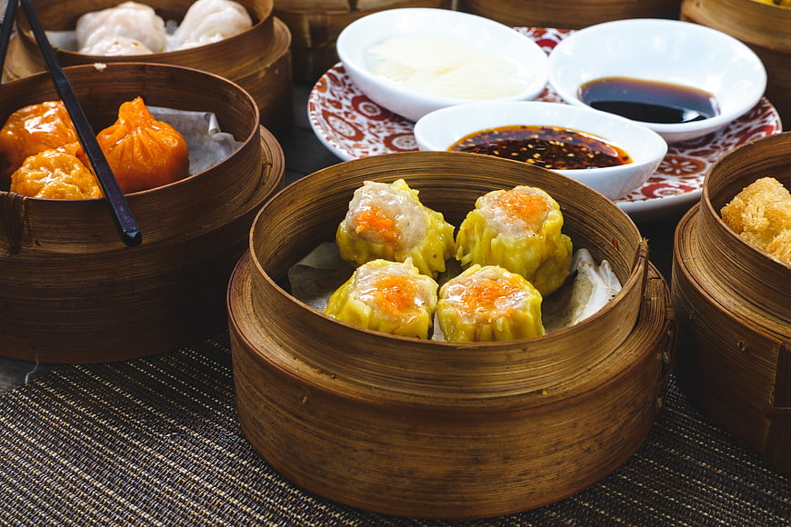 Assorted Chinese Dim Sum in Bamboo Steamers with Dipping Sauces