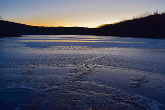 Frozen Lake Landscape at Sunset with Golden Horizon