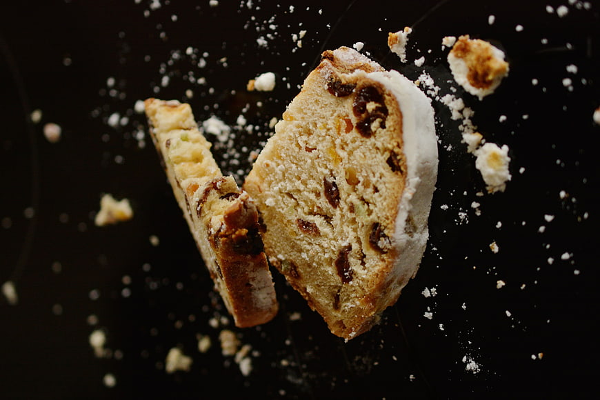 Slices of Christmas Cake with Powdered Sugar on Black Background