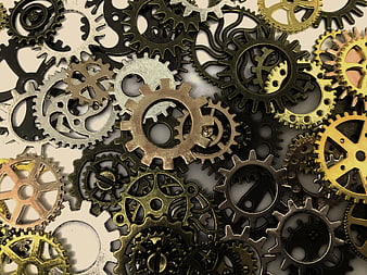 Vintage brass and steel gears scattered on beige background