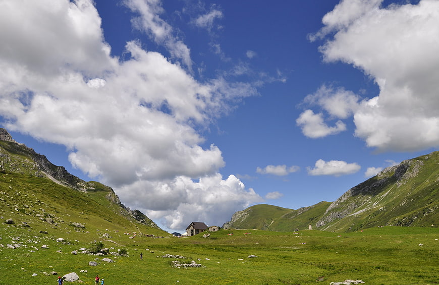 Alpine mountain refuge in green valley with blue sky