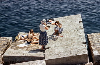 High angle view of women sunbathing on concrete pier