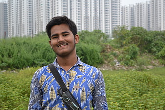 Young man smiling outdoors with city skyline background