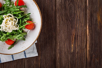 Fresh Arugula Salad with Cherry Tomatoes and Creamy Dressing on Wooden Table