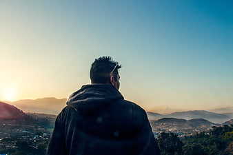 Man Looking at Sunset Over Mountain Valley Landscape