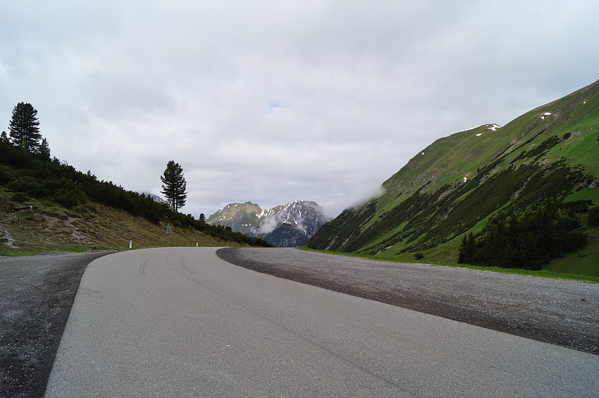 Winding Mountain Road in the Alps with Green Hills