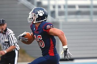 American Football Player Running with Ball in Blue Jersey