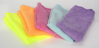 Stack of colorful microfiber cleaning cloths on white background