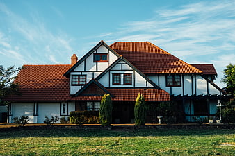 Charming Tudor-style house with red tiled roof and green lawn
