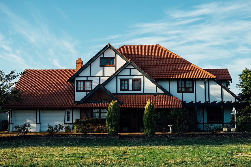 Charming Tudor-style house with red tiled roof and green lawn