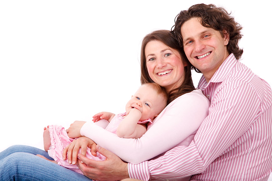 Happy family portrait with mother, father, and baby on white background