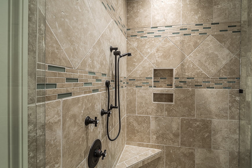 Modern beige tiled shower with black fixtures and bench