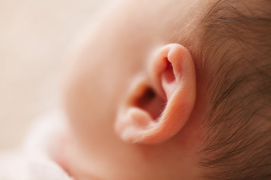 Close-up of a newborn baby's ear and fine hair