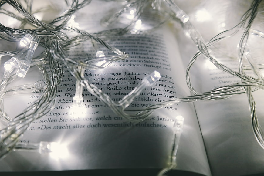 Christmas fairy lights tangled on open book pages