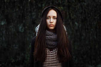 Portrait of young woman in winter scarf and hoodie