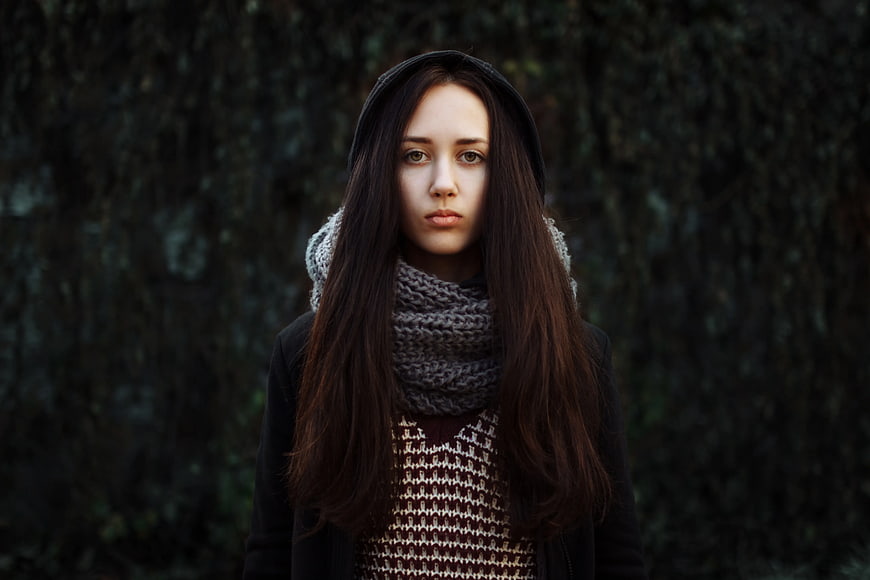 Portrait of young woman in winter scarf and hoodie