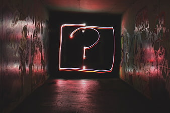 Neon light painting question mark in graffiti tunnel