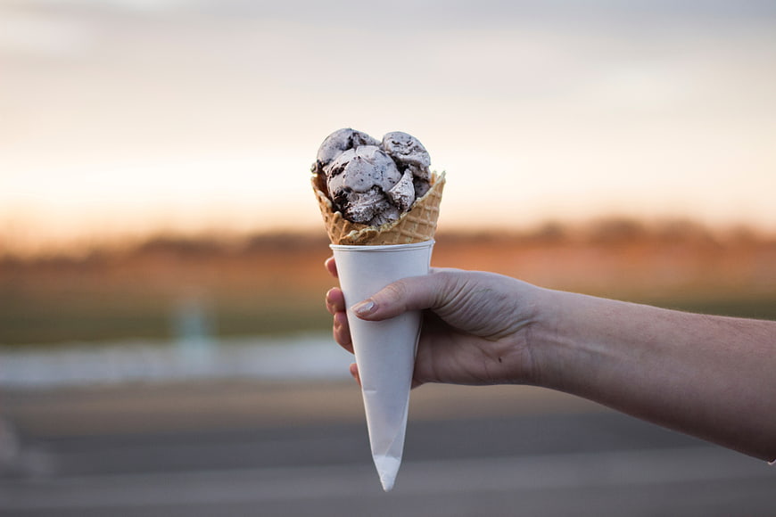 Hand Holding Ice Cream Cone at Sunset